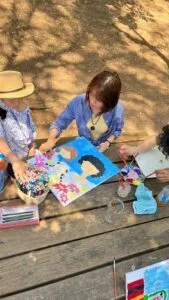Enfants et adultes peignant ensemble lors de la Journee de la Paix